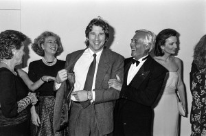 Actor Richard Gere shows designer Giorgio Armani his suit label, as guests watch the exchange, with socialite Lee Radziwill.