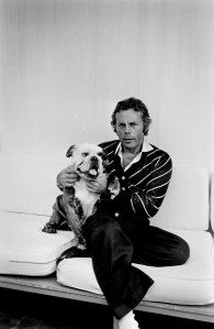 Designer Giorgio Armani and his dog pose during an interview in the designer's Milan home.