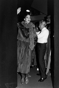 Designer Giorgio Armani adjusts fashion on model Pat Cleveland backstage during presentation of selections from his Fall 1978 Ready to Wear Collection and first Fur Collection, the latter which is exclusive to Bergdorf Goodmn and Neiman Marcus.