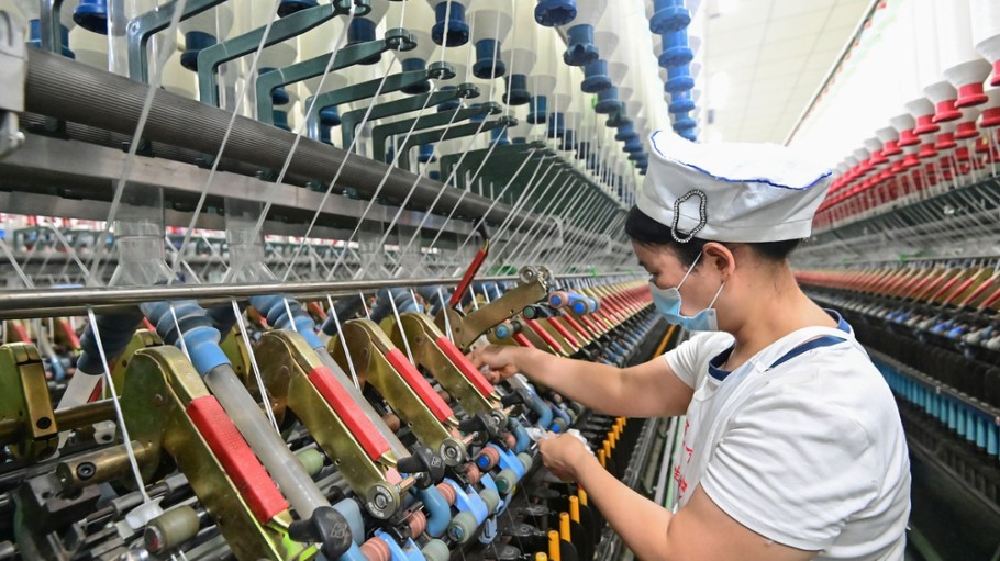 A worker works on a textile processing production line in Qingzhou City, Shandong Province, China, on July 15, 2025. (Photo by Costfoto/NurPhoto via Getty Images)