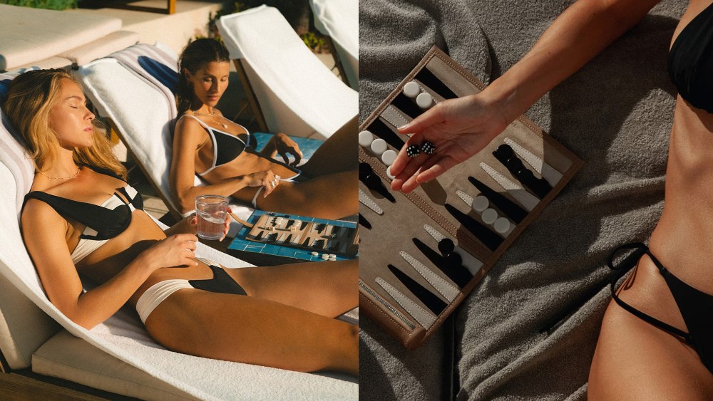 two women resting on pool loungers with a backgammon game between them; woman throwing dice on a board while wearing bikini