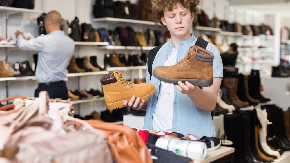 Teenage boy shopping for boots