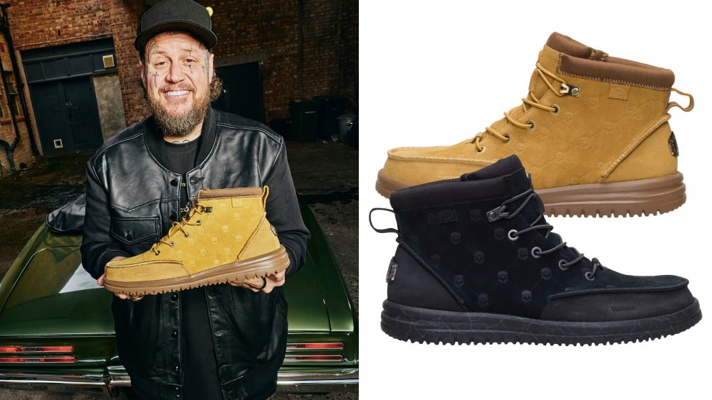 jelly roll holding up his collaboration HeyDude boot in a tan/brown color; the boots in black and tan/brown over a white background