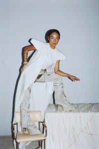 Rick Owens denim coat; cotton T-shirt; nylon canvas pants and bioplastic fender top and boots; Tiffany & Co. Jean Schlumberger by Tiffany ring in platinum and gold with a fancy intense yellow diamond and white diamonds; Tiffany & Co. Schlumberger® diamond stitches bracelet in platinum and 18-karat gold.