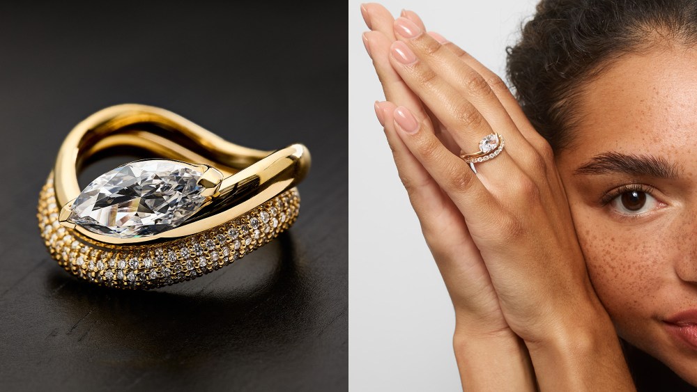close-up shot of a ring stack with a central, oblong diamond; woman holding up both hands, with one of them adorned by a sculptural, wave-like ring