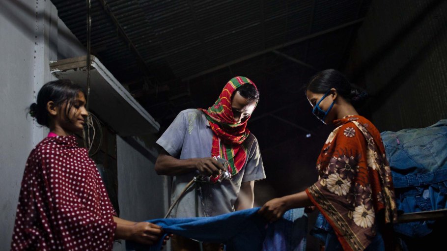 Workers are spraying potassium permanganate in a washing factory on in Dhaka, Bangladesh.