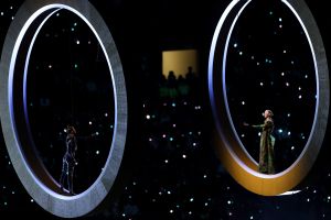 Two aerial actors perform next to the rings representing the city and mountain during the opening ceremony of the Milano Cortina 2026 Winter Olympics.