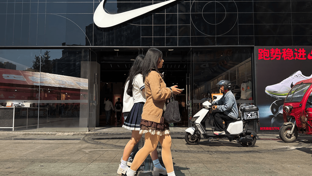 Shoppers walk past a Nike store in China.