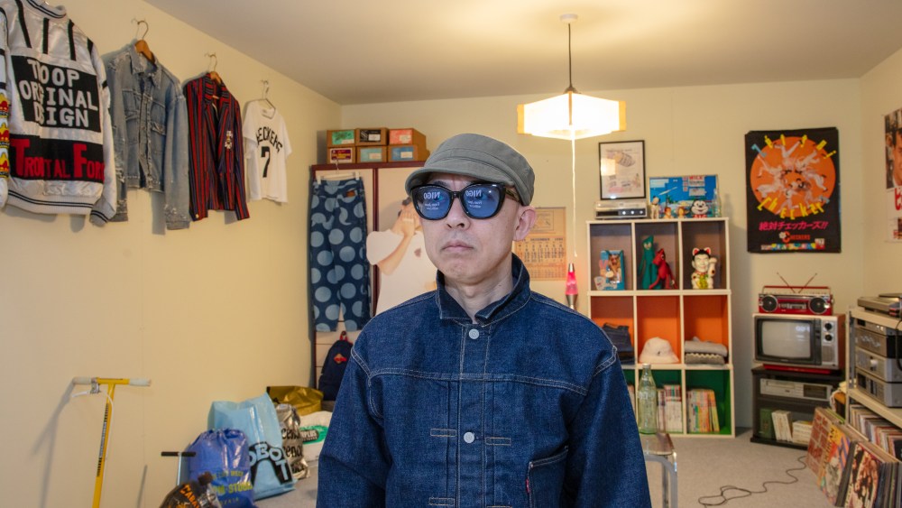 Nigo in front of a recreation of his childhood bedroom at the "Nigo from Japan with Love" exhibition at the Design Museum in London