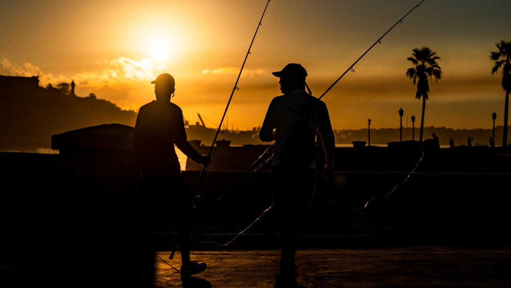 Fishermen walk along Havana's Malecon atsunrise on October 28, 2022. (Photo by YAMIL LAGE / AFP) (Photo by YAMIL LAGE/AFP via Getty Images)